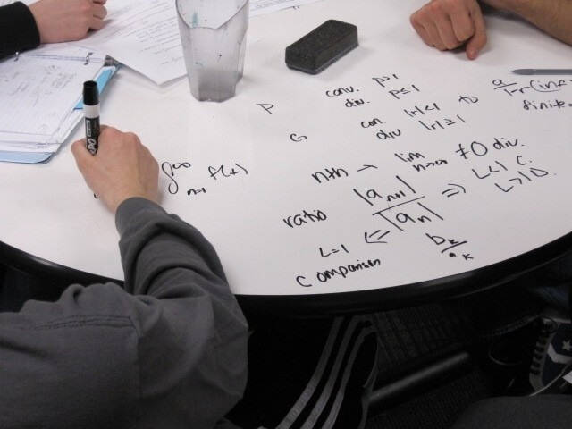 A white board table with formulas written on it